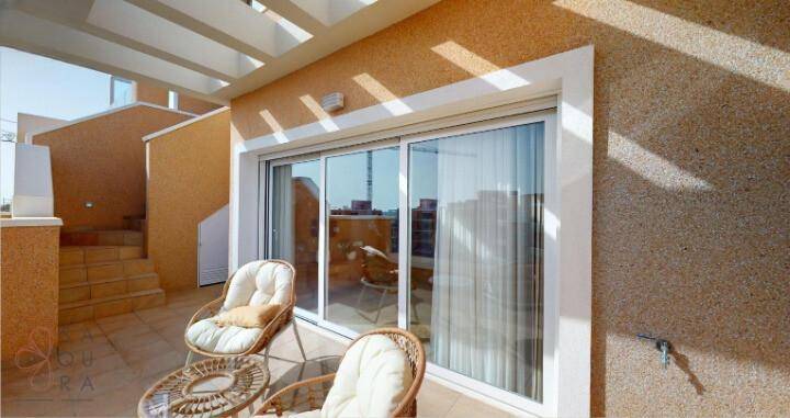 Sonniger Balkon mit Sitzgelegenheiten und Blick auf die Umgebung, ideal zum Entspannen.
