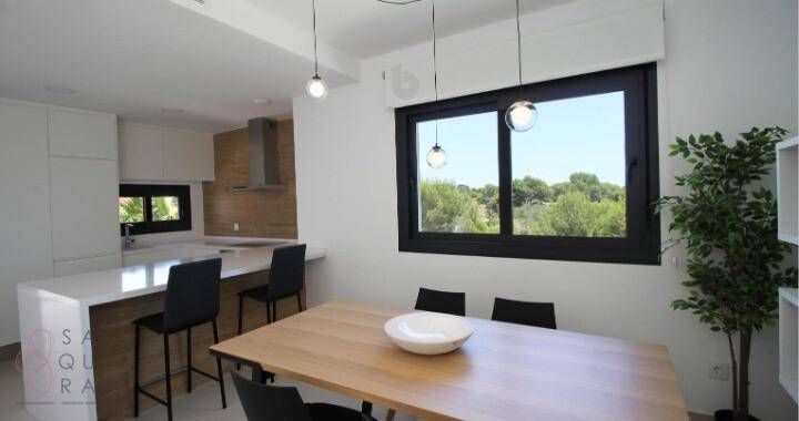 Moderne Küche mit Essbereich, Bar und Fenster mit Blick ins Grüne.