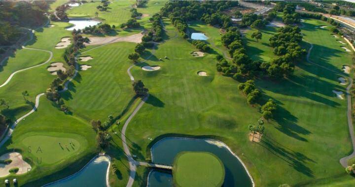 Luftaufnahme eines weitläufigen Golfplatzes mit Wasserhindernissen und Grüns.