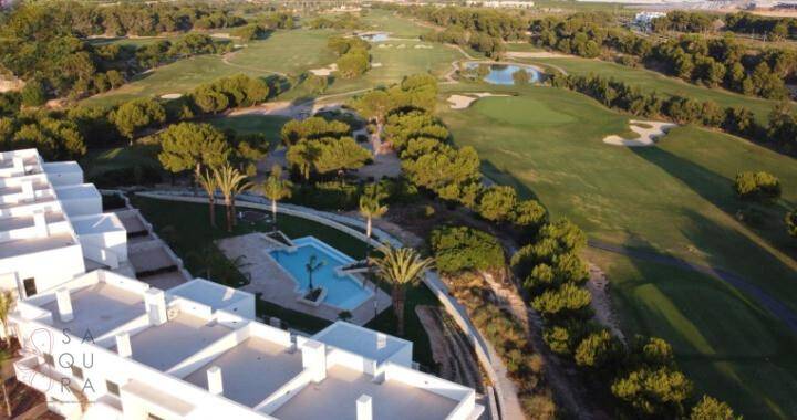 Luftaufnahme der Wohnanlage mit Golfplatz und weitläufiger Grünfläche.
