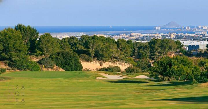 Panoramablick über den Golfplatz mit Stadt und Meer in der Ferne.