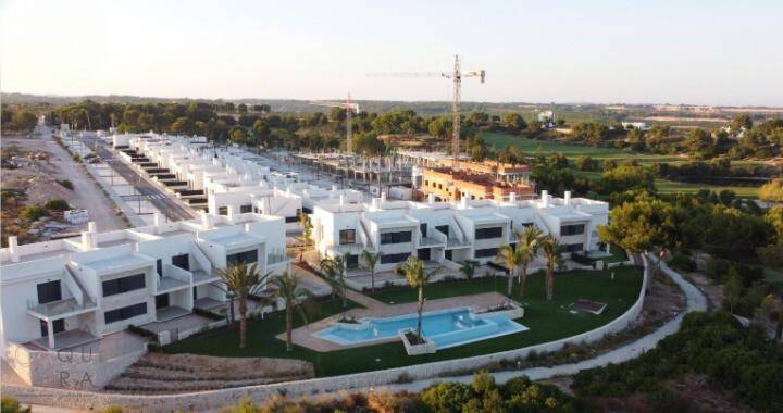 Luftaufnahme der Wohnanlage mit Pool und angrenzendem Golfplatz.