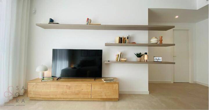 Wohnbereich mit modernem TV-Möbel aus Holz und schwebenden Regalen für Dekoration.