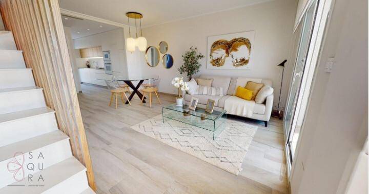 Heller Wohn- und Essbereich mit modernem Design, Holzboden und offener Treppe.