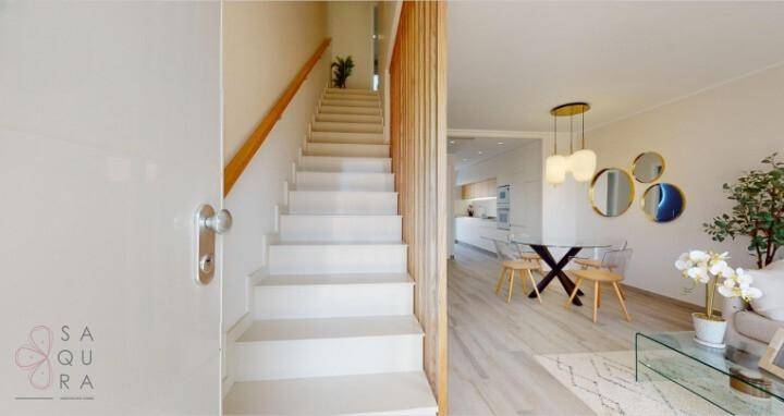 Moderne Treppe mit Holzgeländer führt in den oberen Bereich, angrenzend an den Wohnbereich.