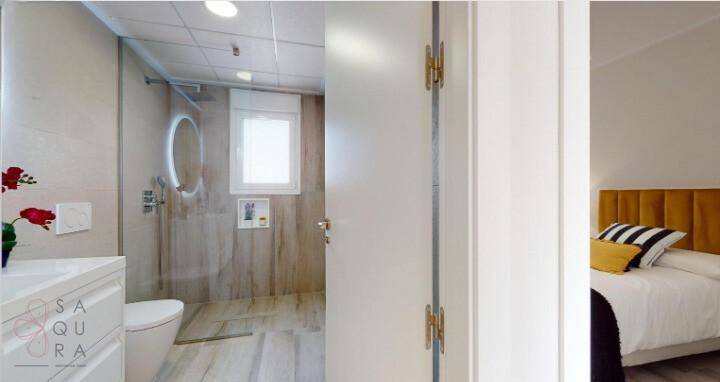 Modernes Badezimmer mit Dusche und Blick in ein angrenzendes Schlafzimmer.