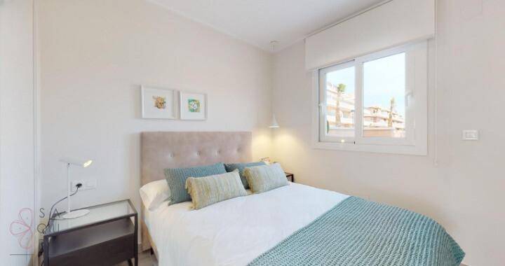 Gemütliches Schlafzimmer mit Doppelbett, Nachttisch und Fenster für natürliches Licht.