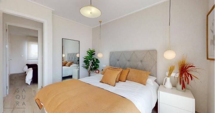 Modern eingerichtetes Schlafzimmer mit Doppelbett, Spiegel und Blick in einen weiteren Raum.