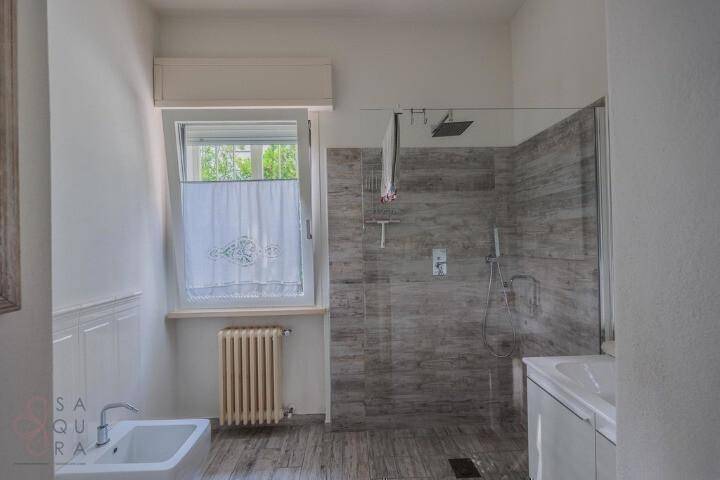 Modernes Badezimmer mit begehbarer Dusche, Bidet und einem Fenster für Tageslicht.
