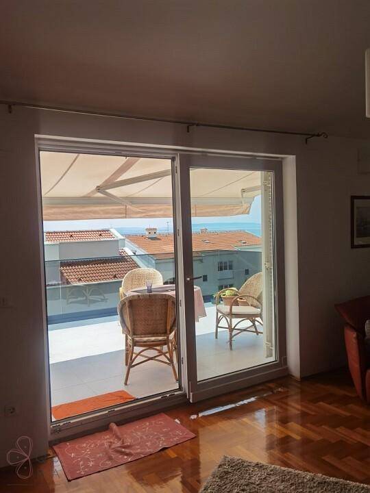 Heller Wohnbereich mit Zugang zum Balkon und weitem Blick auf das Meer und die Umgebung.