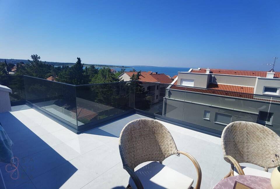 Geräumiger Balkon mit moderner Glasbrüstung und Panoramablick auf das Meer und die Umgebung.