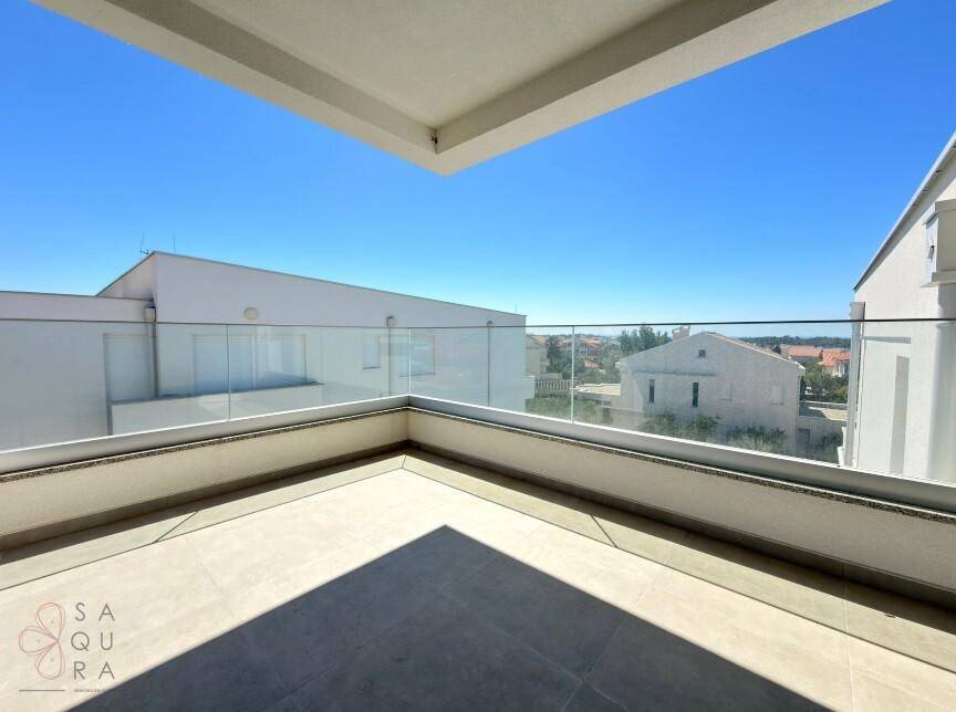 Geräumiger Balkon mit Glasgeländer und weitem Blick auf die Umgebung und den Horizont.