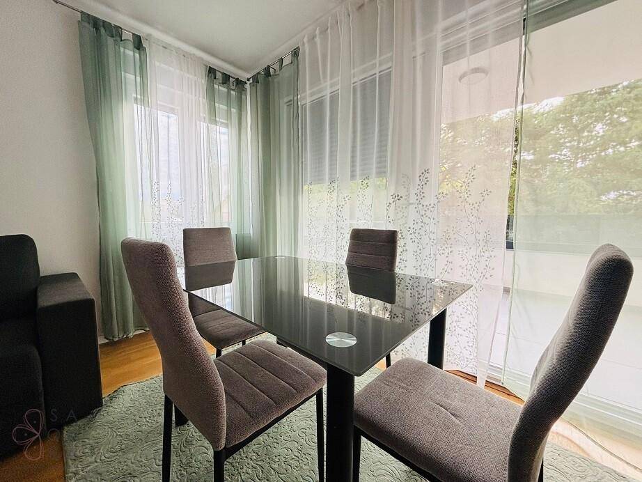 Essbereich mit elegantem Glastisch, bequemen Stühlen und lichtdurchlässigen Vorhängen.