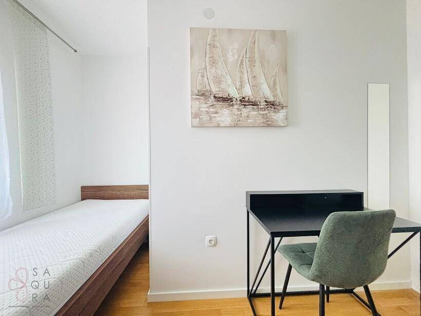 Schlafzimmer mit Einzelbett, Schreibtisch und einem maritimen Wandbild.