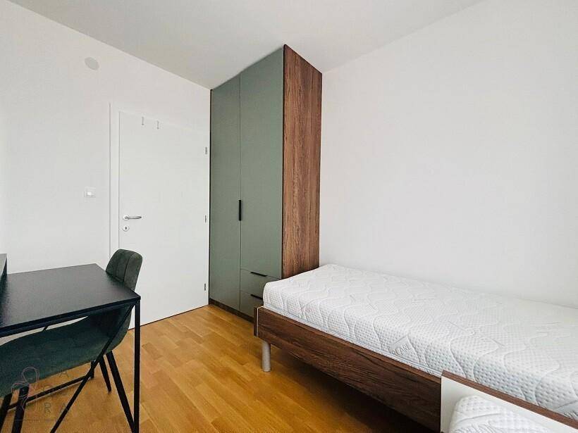 Jugendzimmer mit Einzelbett, Schreibtisch, Stuhl und einem modernen Kleiderschrank.