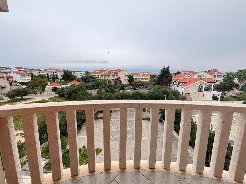Balkon mit weitem Blick über eine Wohnsiedlung mit vielen Häusern und Grünflächen.
