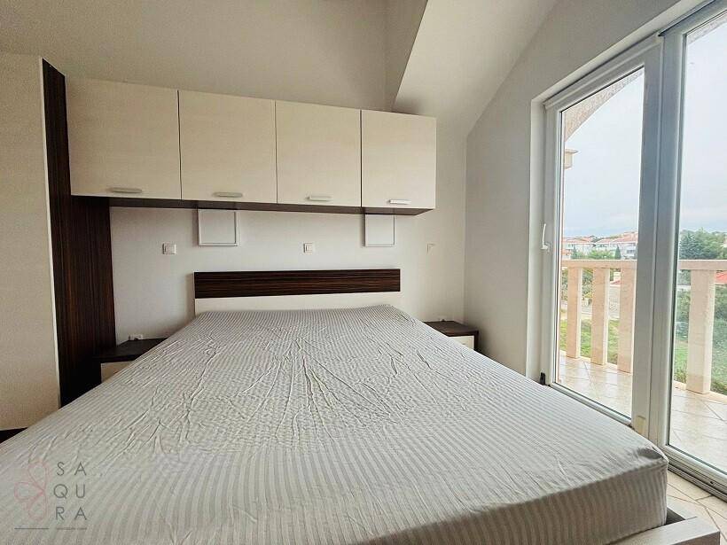 Schlafzimmer mit Doppelbett, Einbauschränken und direktem Zugang zum Balkon.