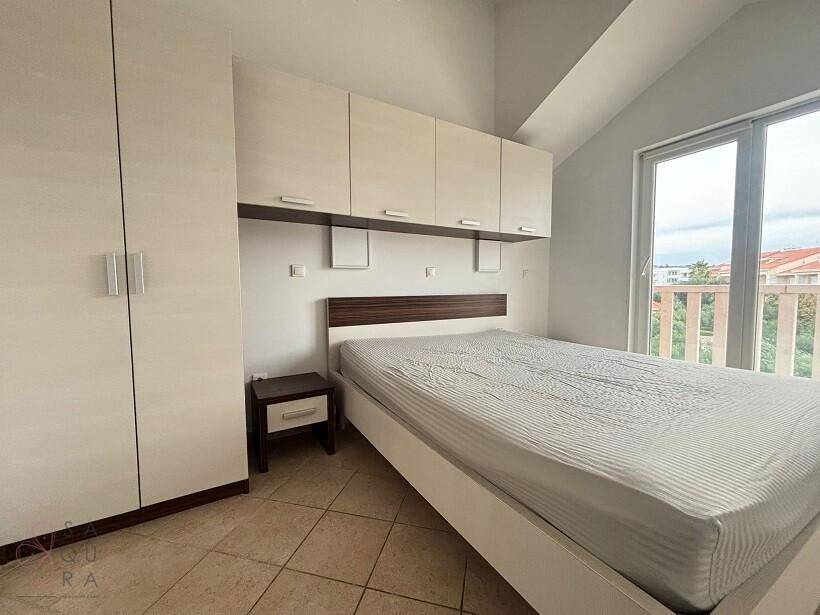 Schlafzimmer mit Doppelbett, Einbauschränken, Kleiderschrank und Balkonzugang.