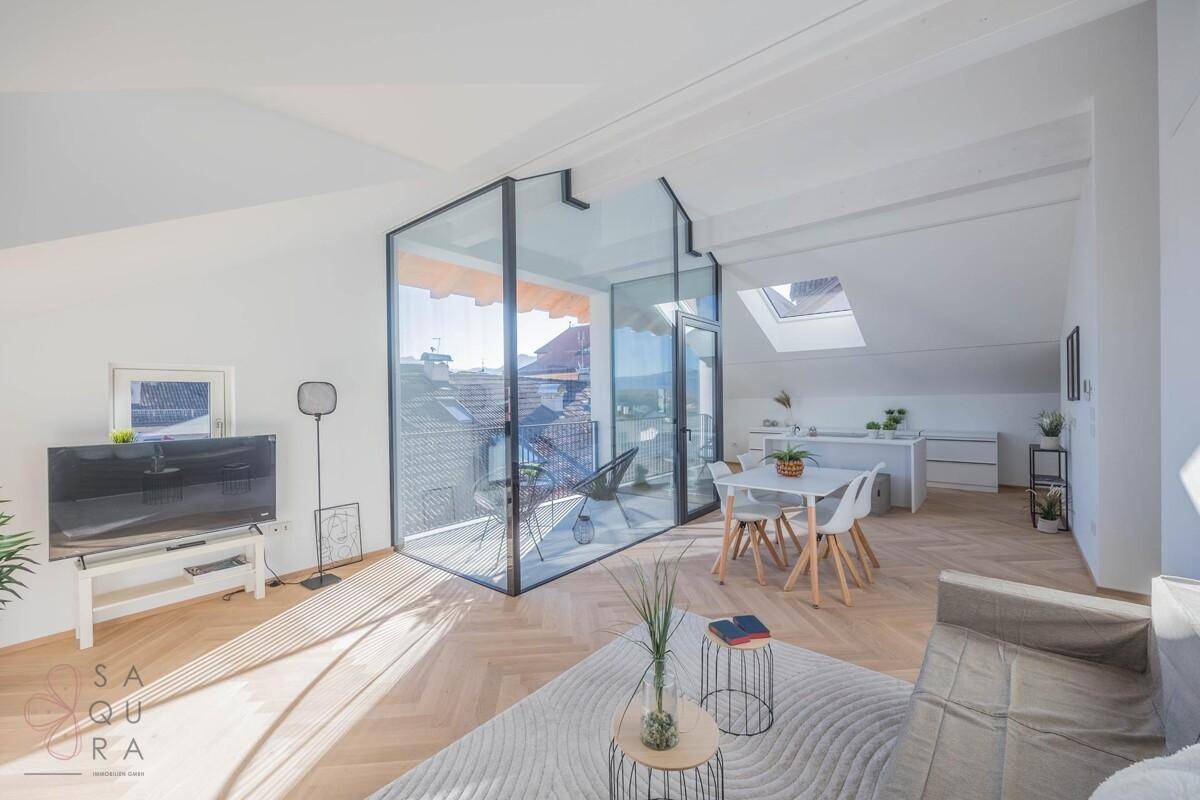 Lichtdurchfluteter Wohnbereich mit modernem Interieur, Holzboden und direktem Zugang zum Balkon.