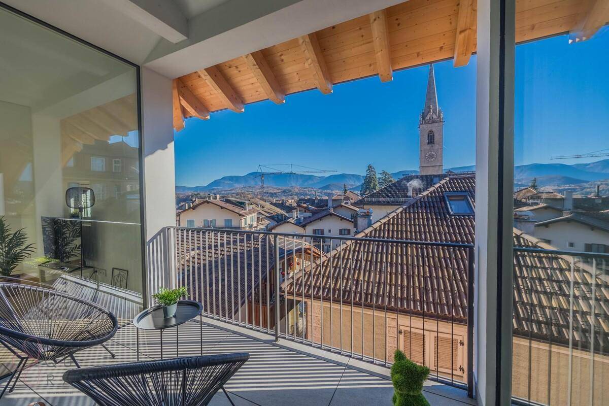 Sonniger Balkon mit gemütlichen Sitzgelegenheiten und weitem Blick über die Dächer der Stadt.