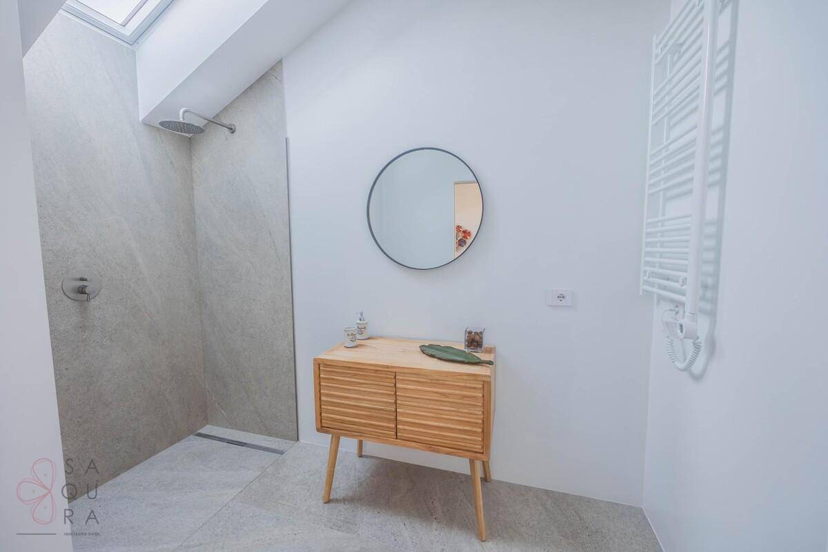 Modernes Badezimmer mit begehbarer Dusche, Holzwaschtisch und Dachfenster.