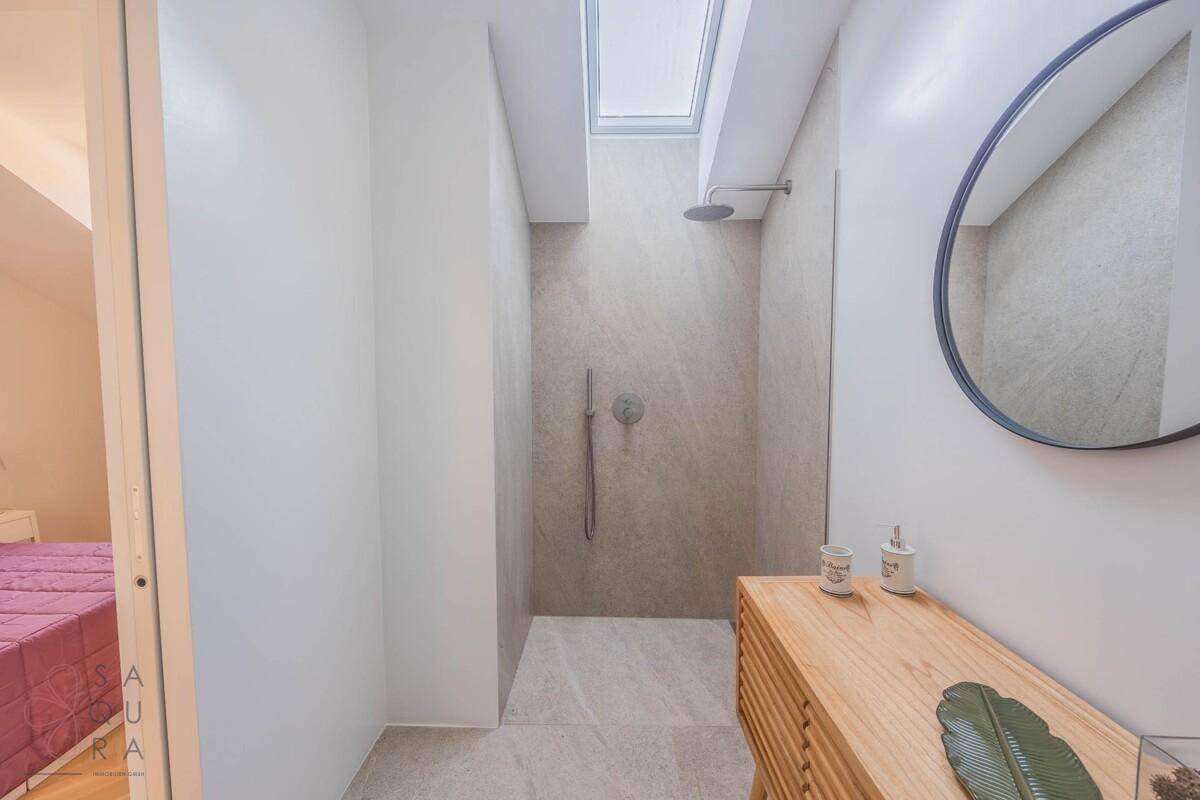 Modernes Badezimmer mit großer begehbarer Dusche, Dachfenster und Holzwaschtisch.