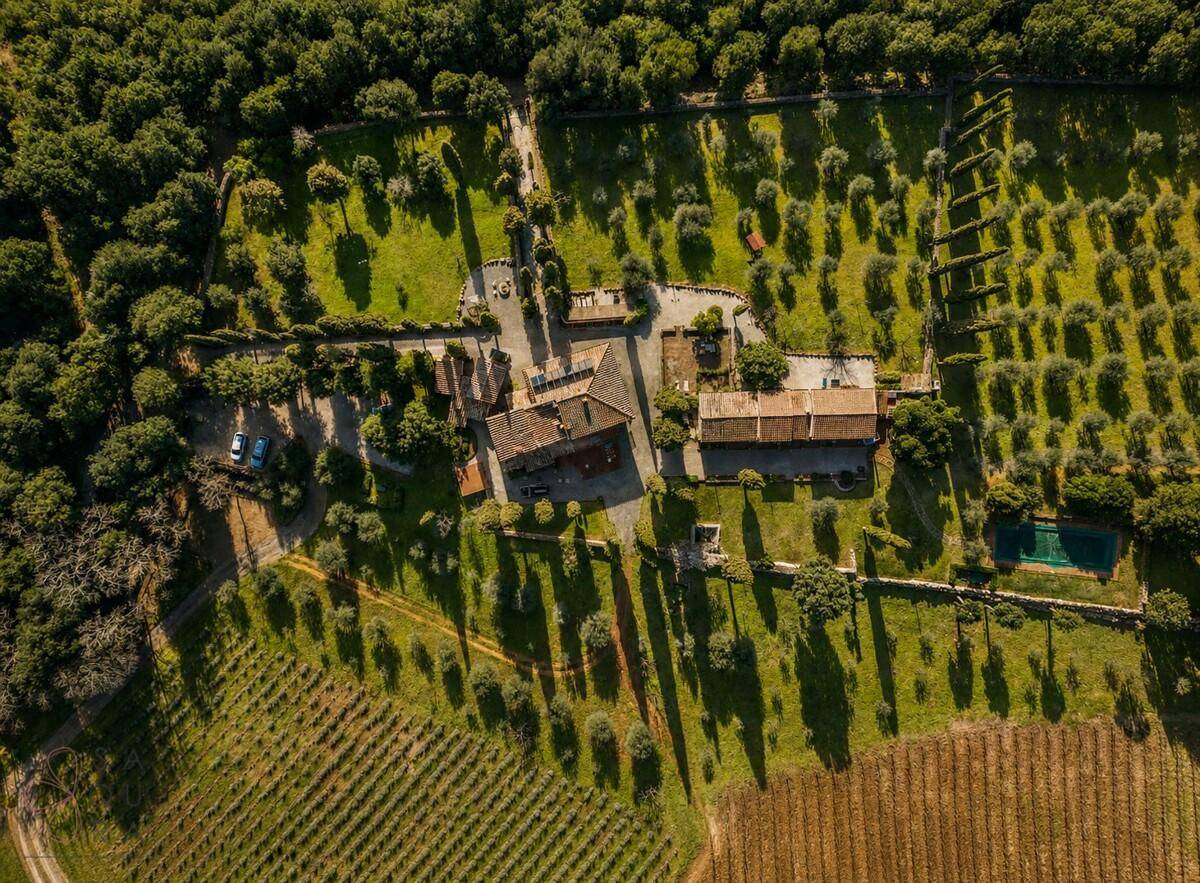 Luftaufnahme des Anwesens mit weitläufigen Weinbergen, Olivenhainen und Gebäudekomplex.
