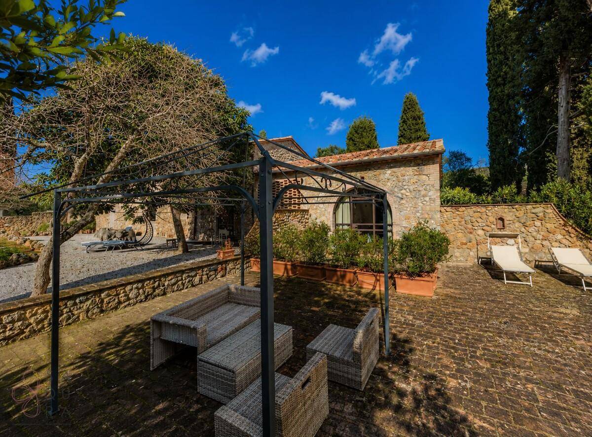 Gemütliche Terrasse mit Pergola und Korbmöbeln, ideal für entspannte Stunden im Freien.