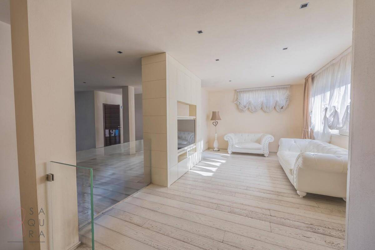 Helles Wohnzimmer mit weißem Sofa, hellen Holzböden und moderner Einrichtung.