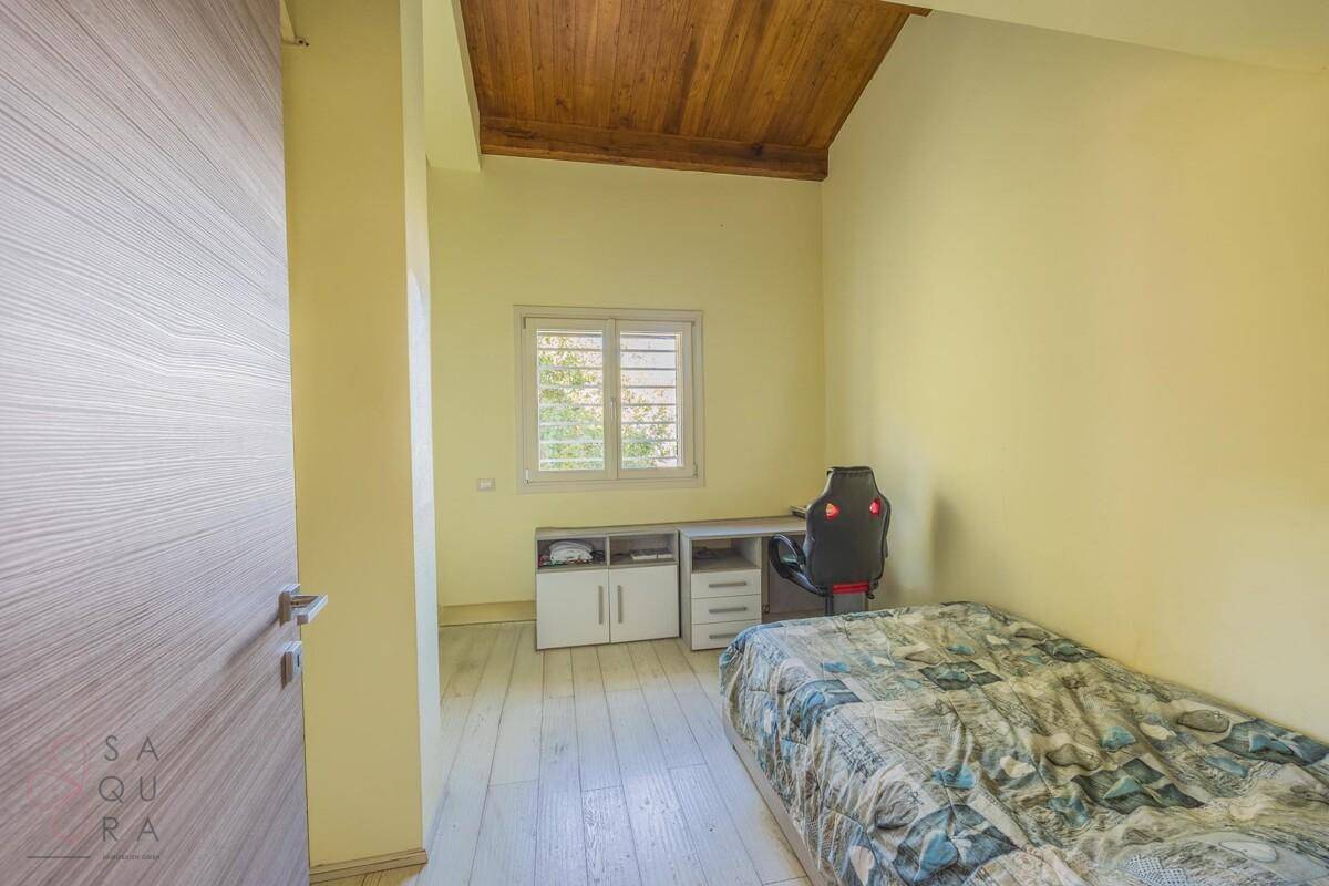 Helles Kinderzimmer oder Arbeitszimmer mit Holzbalkendecke, Schreibtisch und Einzelbett.