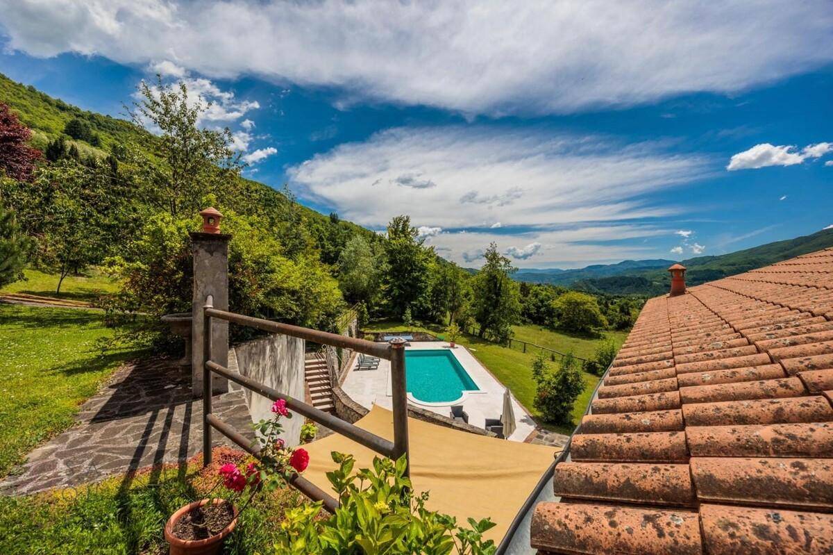 Außenbereich mit Pool und Blick auf die malerische Berglandschaft unter blauem Himmel.