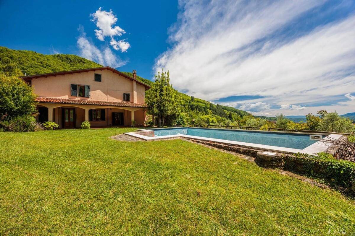 Haus mit großem Garten, Swimmingpool und weitem Blick auf die grüne Hügellandschaft.