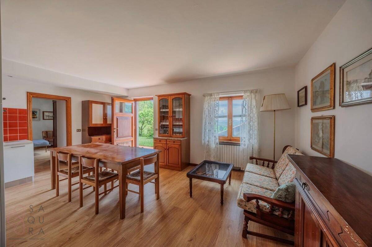 Wohnbereich mit Zugang zum Garten, Esstisch und gemütlicher Sitzecke.