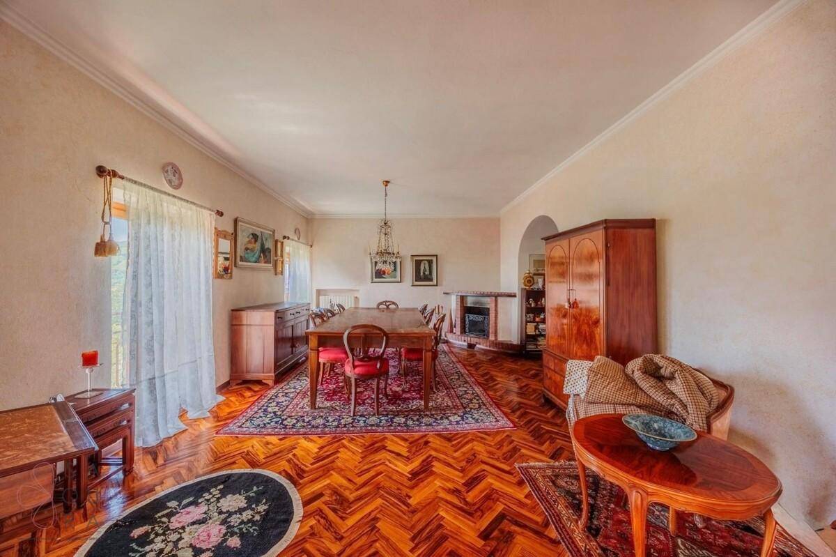 Elegantes Esszimmer mit großem Holztisch, Fischgrätparkett und klassischer Einrichtung.