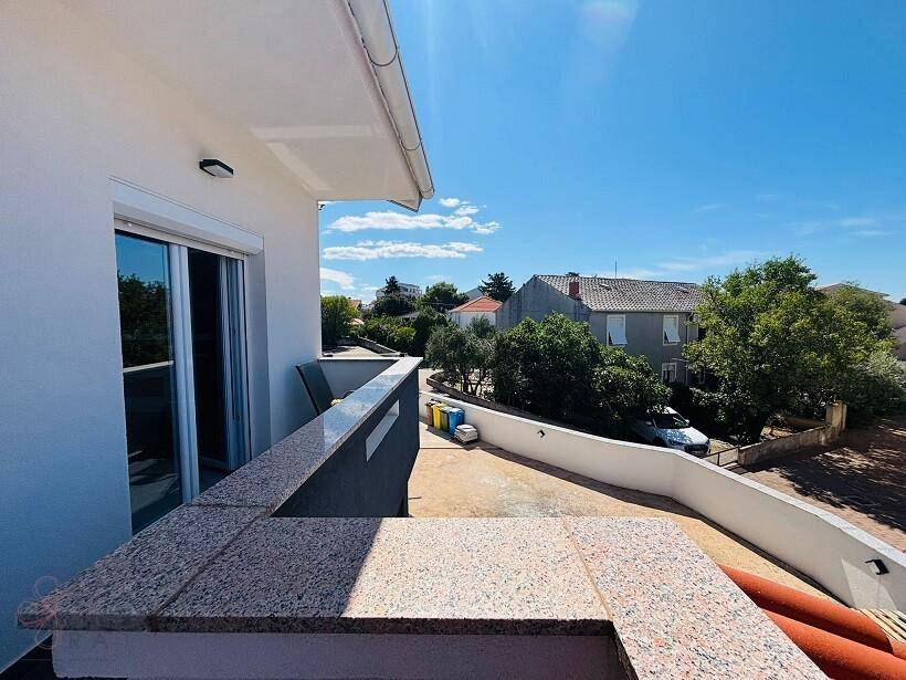 Geräumiger Balkon mit Granitbrüstung und weitem Blick über die umliegende Wohngegend.
