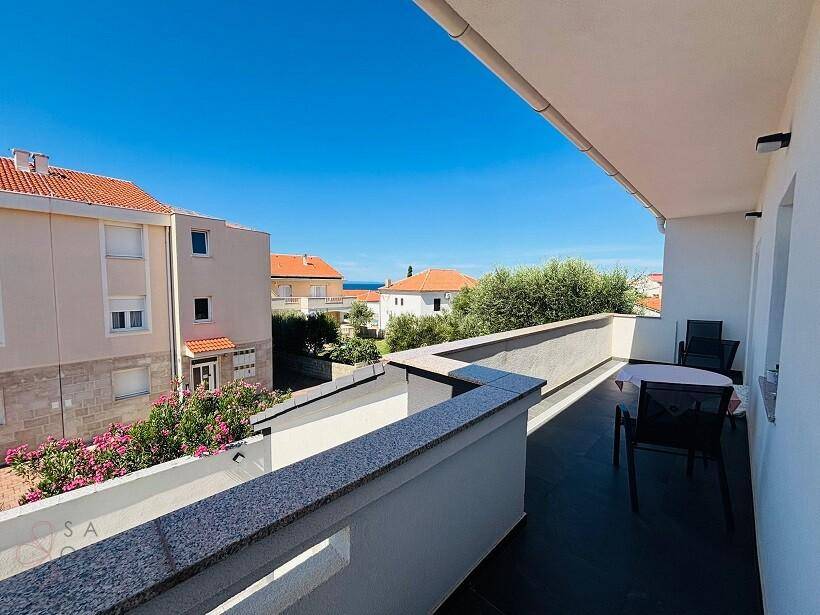 Großer Balkon mit Sitzgelegenheiten, Granitbrüstung und einem schönen Blick auf das Meer in der Ferne.