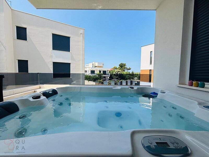 Weitläufige Terrasse mit luxuriösem Whirlpool und Panoramablick auf die Umgebung.