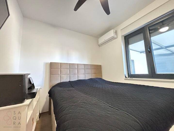 Schlafzimmer mit Doppelbett, Klimaanlage und Fenster für natürliches Licht.