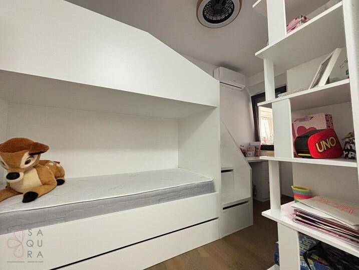Kinderzimmer mit Etagenbett, integrierten Regalen und Klimaanlage.