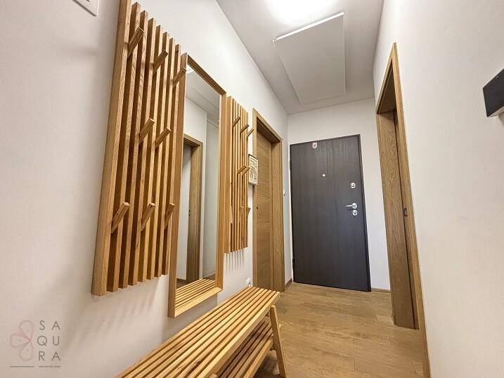 Heller Flur mit Holzboden, Garderobe und Spiegel, einladender Eingangsbereich.