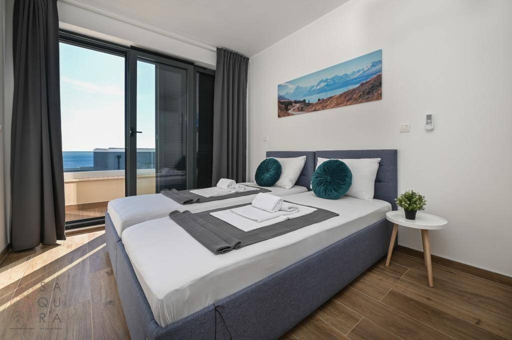 Komfortables Schlafzimmer mit zwei Einzelbetten und Balkon, der einen schönen Meerblick ermöglicht.