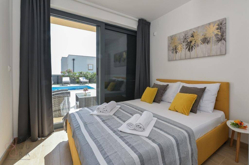 Gemütliches Schlafzimmer mit Doppelbett und direktem Zugang zur Terrasse mit Poolblick.