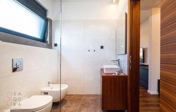 Helles Badezimmer mit modernem Waschtisch, Toilette, Bidet und Fenster für Tageslicht.