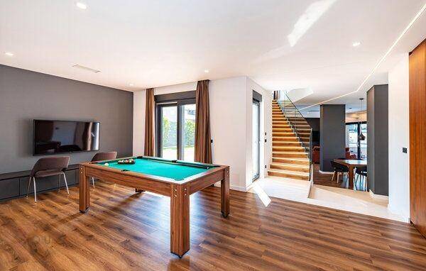 Geräumiger Spielraum mit Billardtisch und Fernseher, ideal für Unterhaltung.