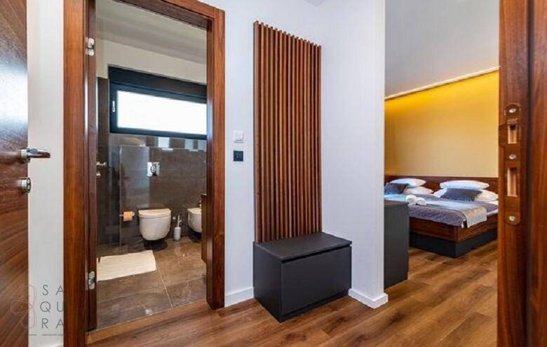 Flur mit Blick auf ein modernes Badezimmer und ein angrenzendes Schlafzimmer.