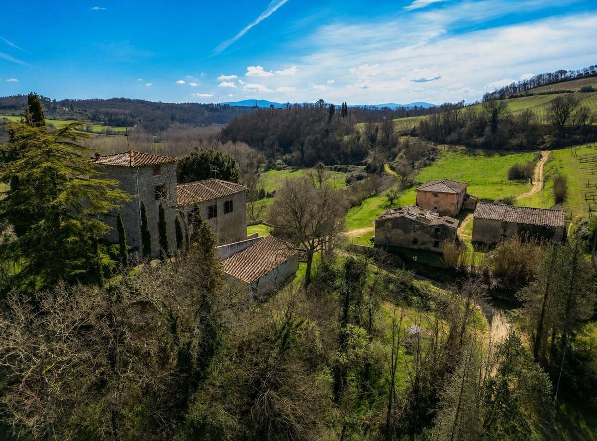 Weitläufiges Anwesen mit mehreren historischen Gebäuden, umgeben von üppiger grüner Landschaft.
