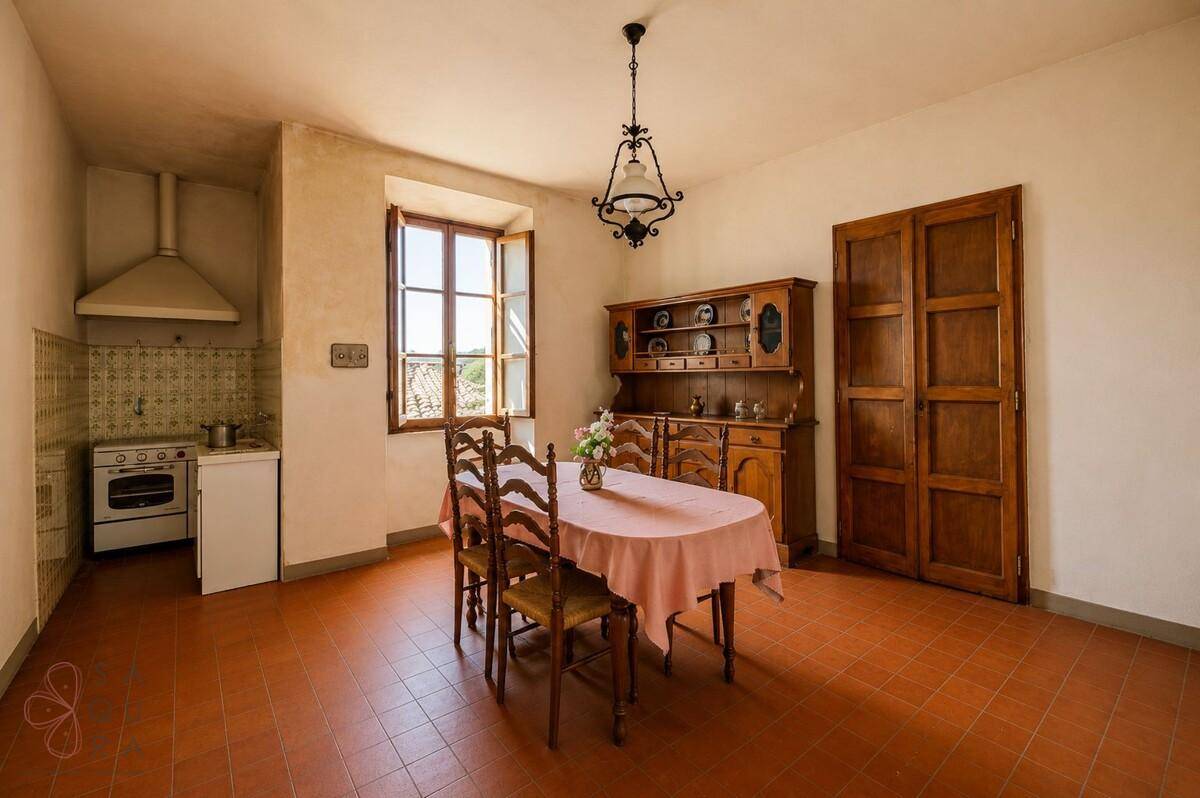 Rustikale Wohnküche mit Esstisch, traditionellen Holzmöbeln und Terrakotta-Fliesenboden.