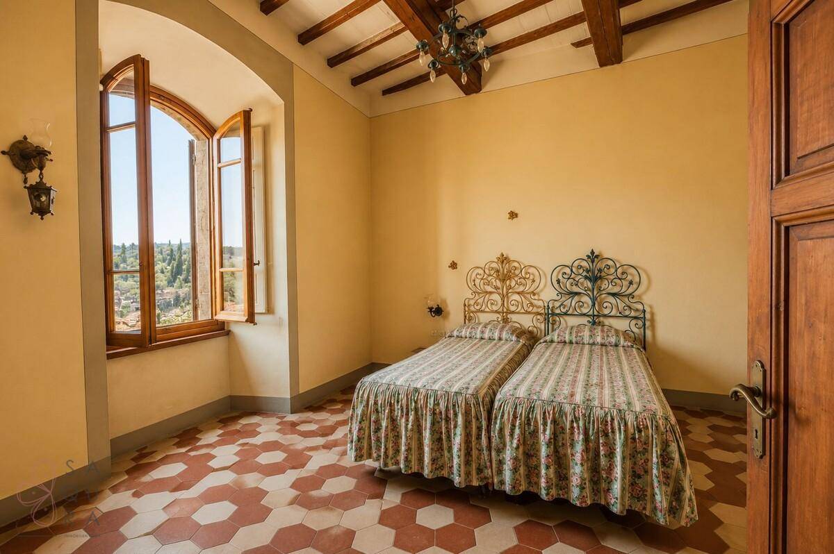 Schlafzimmer mit zwei Einzelbetten, schmiedeeisernen Betten und Blick auf die umliegende Landschaft.