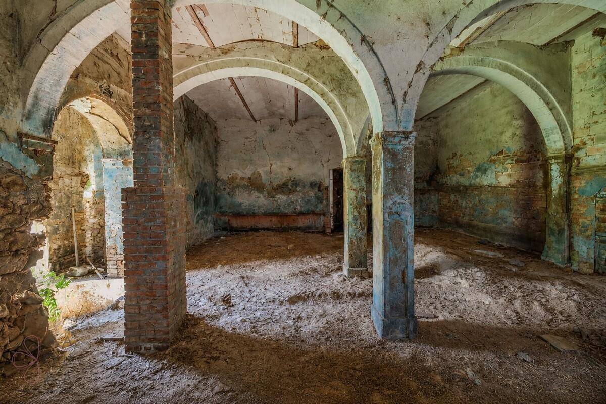Historischer Kellerraum mit gemauerten Bögen, Säulen und sichtbaren Ziegelwänden.