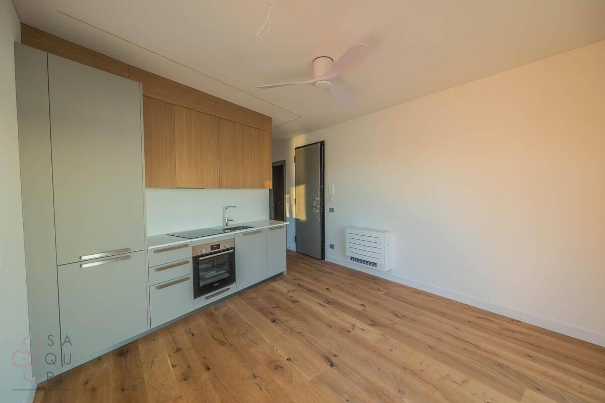 Moderne Küchenzeile in einem hellen Wohnbereich mit Holzboden und minimalistischem Design.
